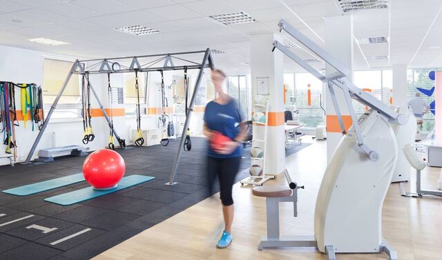 Eine große, offene und helle Trainingsfläche - verschwommen ist eine Person in der Bewegung zu sehen.